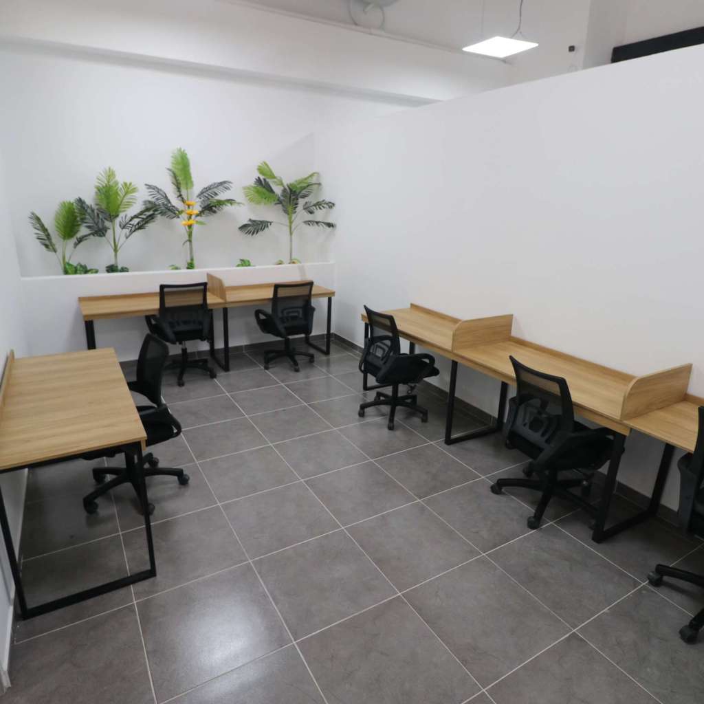 Oficina de 6 personas con escritorios y sillas.
